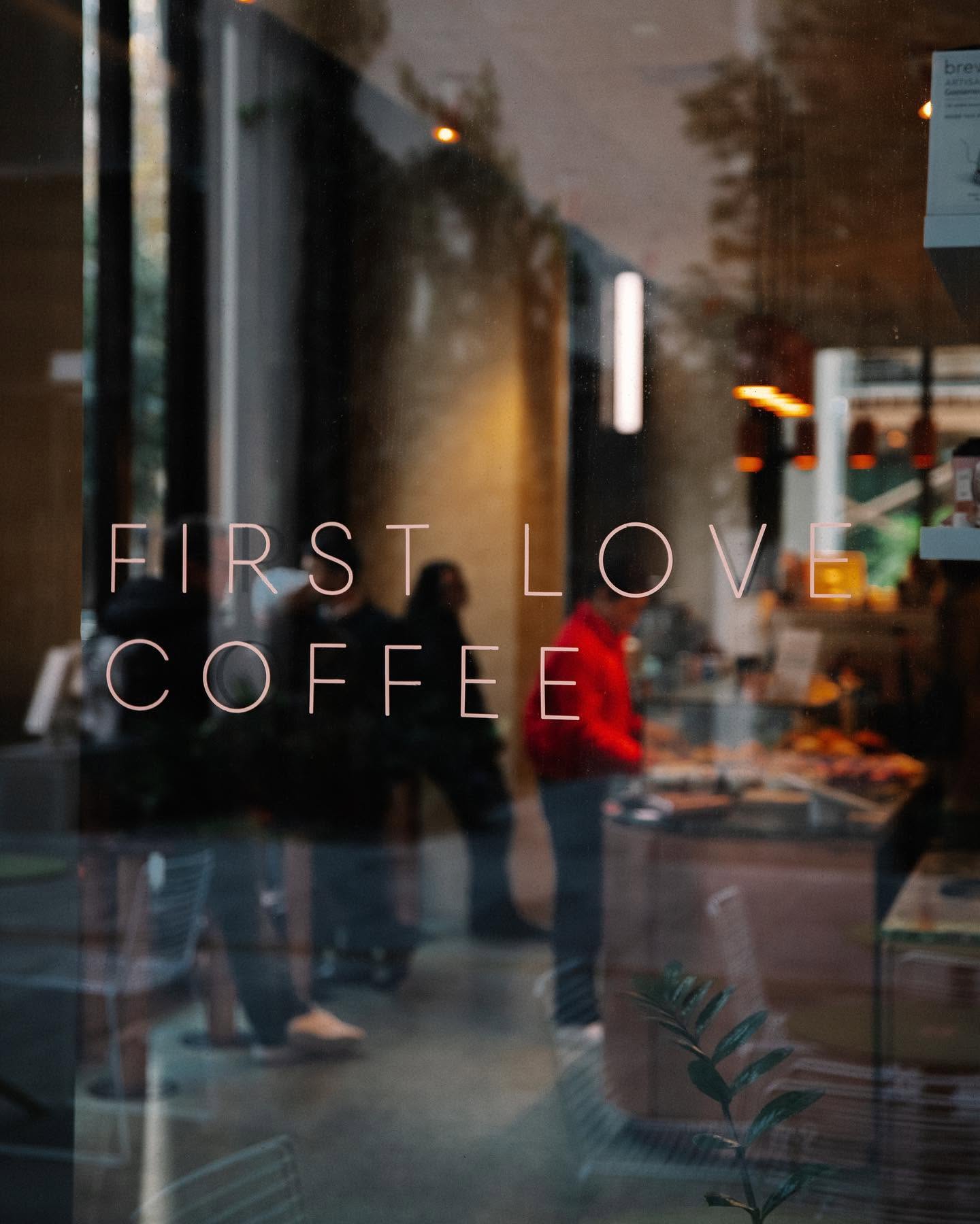 First Love Coffee lettering on the window glass, looking into the bar