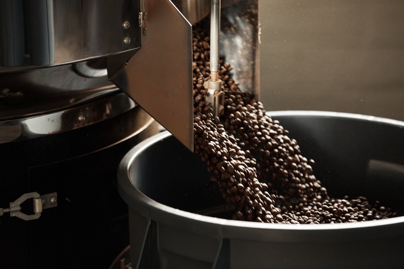 Freshly roasted beans pouring from the roaster